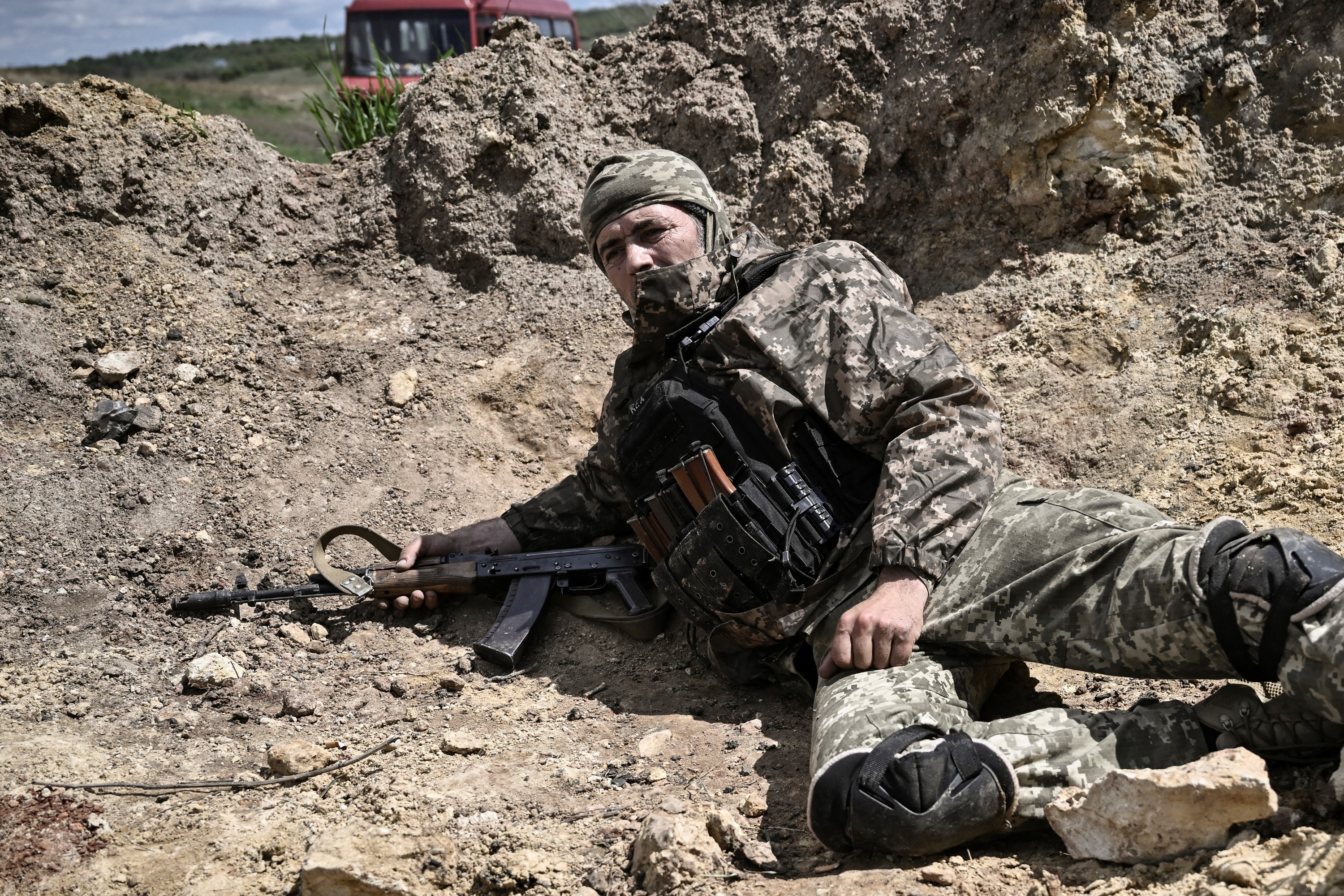 Orosz tüzérségi támadás elől fedezékbe húzódó ukrán katona Liszicsanszk közelében, a szeverodonecki csatában 2022. május 23-án.