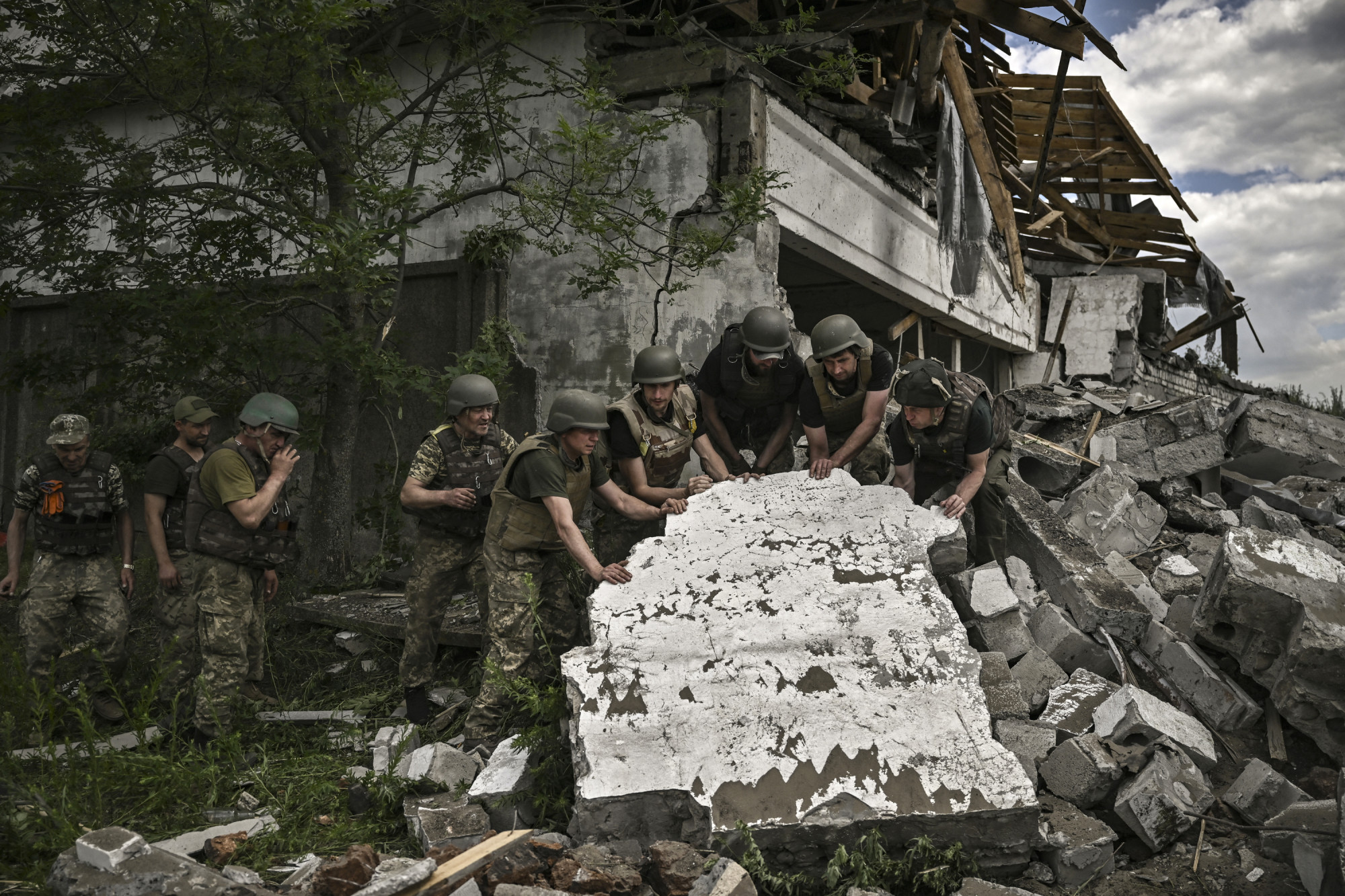 Ukrán katonák egy orosz tüzérségi támadásban megsemmisült rakátépületnél Liszicsanszkban.