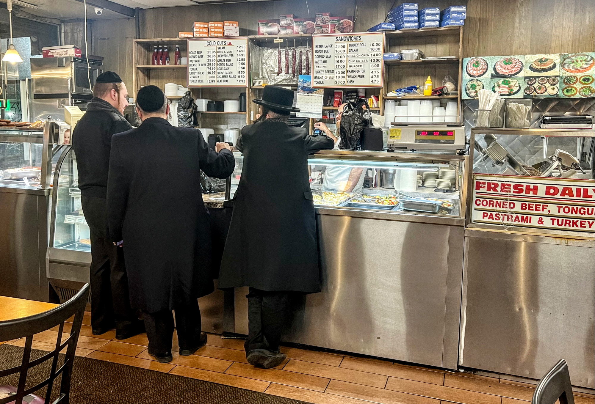 Három haszid férfi várja a rendelését a Gottlieb’s-ben.