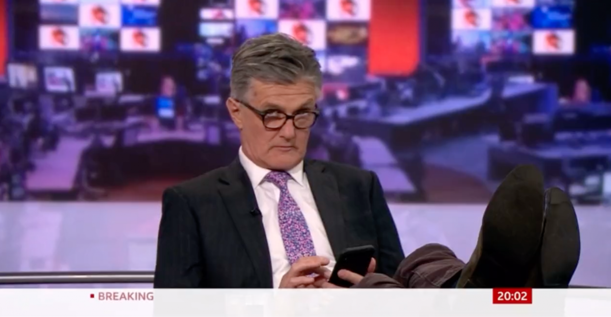 A BBC műsorvezetője lábát az asztalra téve, élő adásban görgette telefonját
