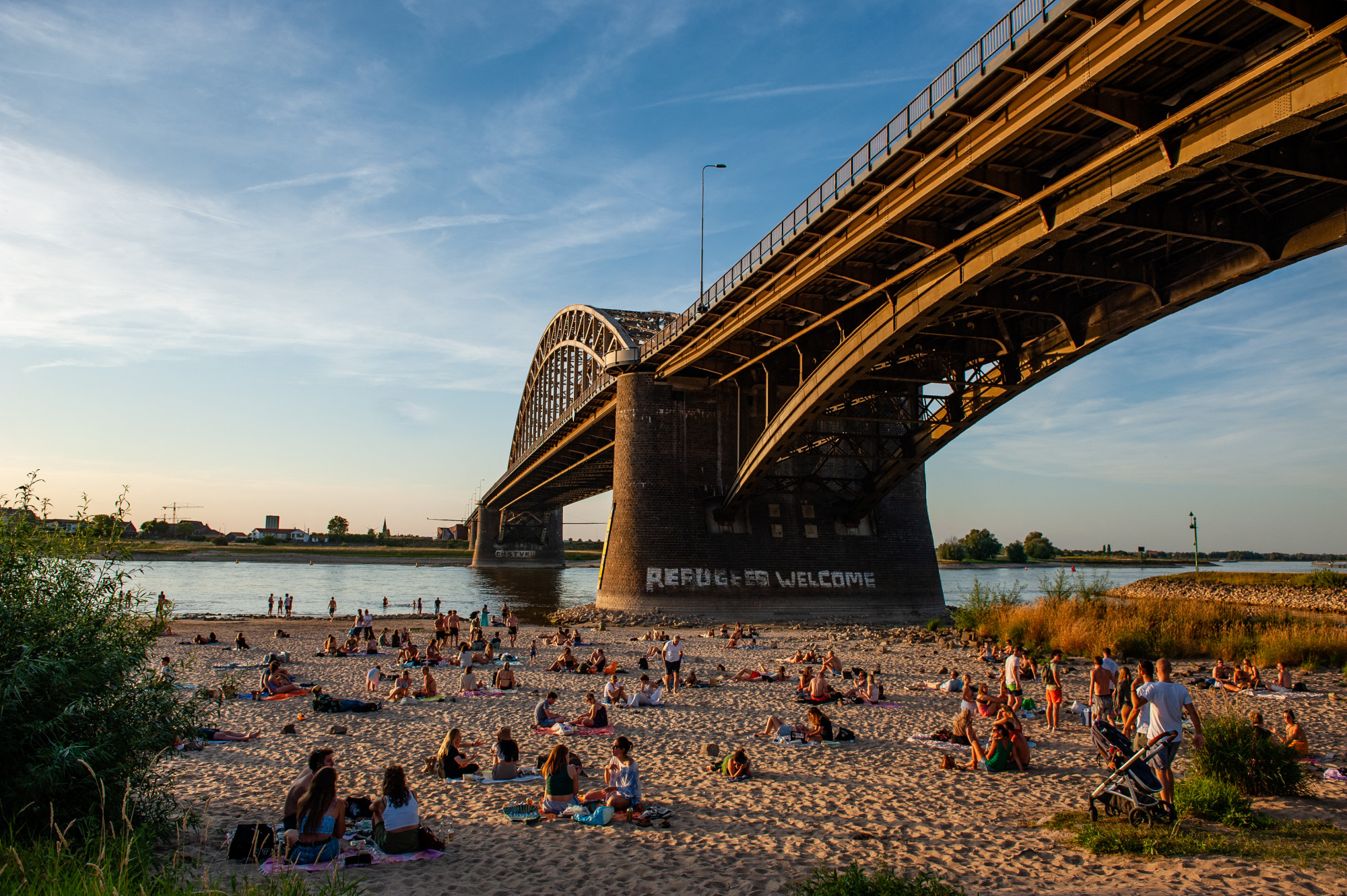 Nijmegeni piknikezők a hollandiai Waal hídja alatt 2022. augusztus 3-án