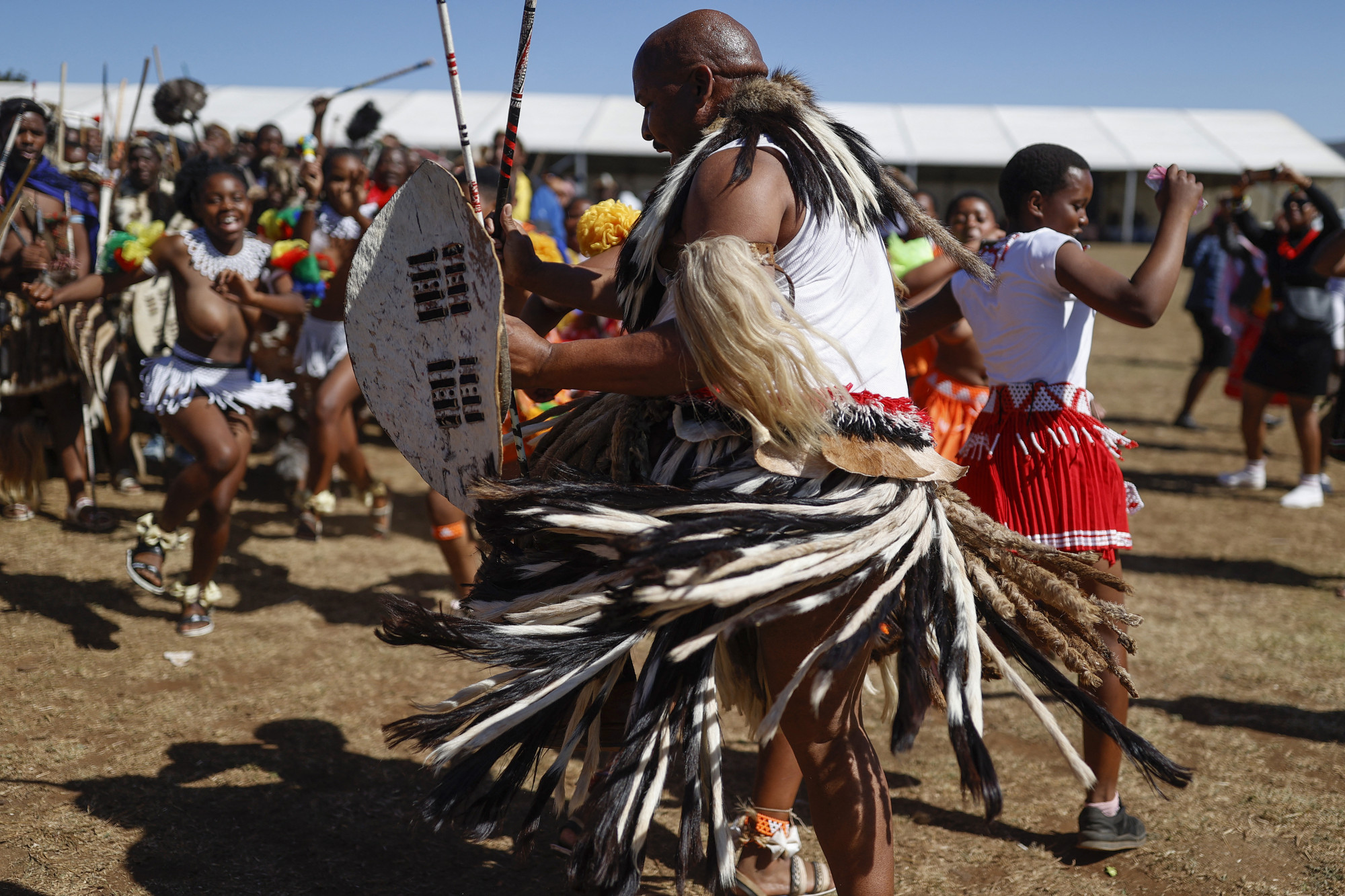 Fiatal zulu lányoko és Amabutho harcosok énekelnek, táncolnak.