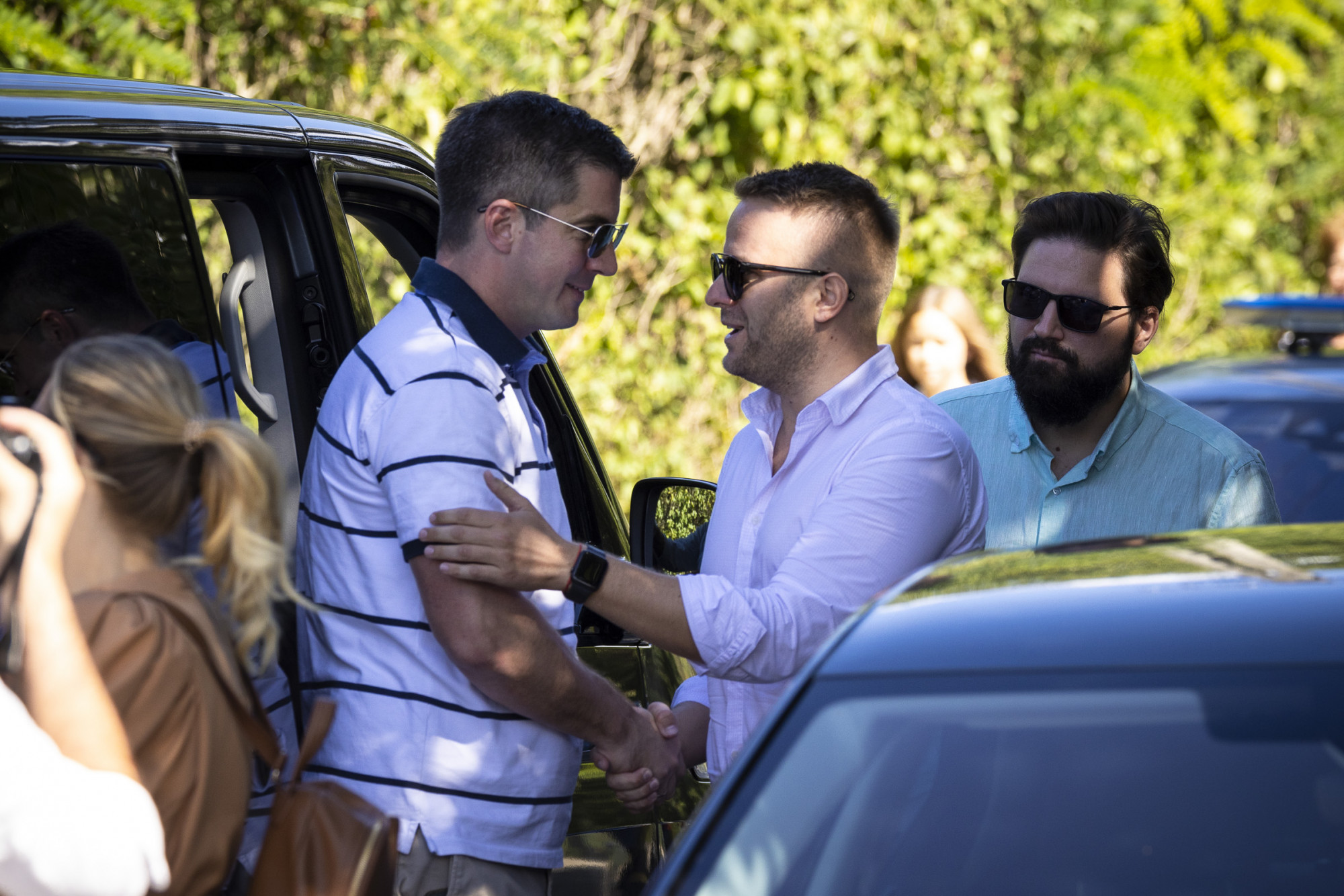 Bohár Dániel, a Megafon munkatársa meglapogatja Kocsis Máté Fidesz-frakcióvezető bicepszét, a háttérben, Kovács István,  a Megafon alapítója figyeli őket Orbán Viktor kötcsei eligazításán 2022. szeptember 10-én.