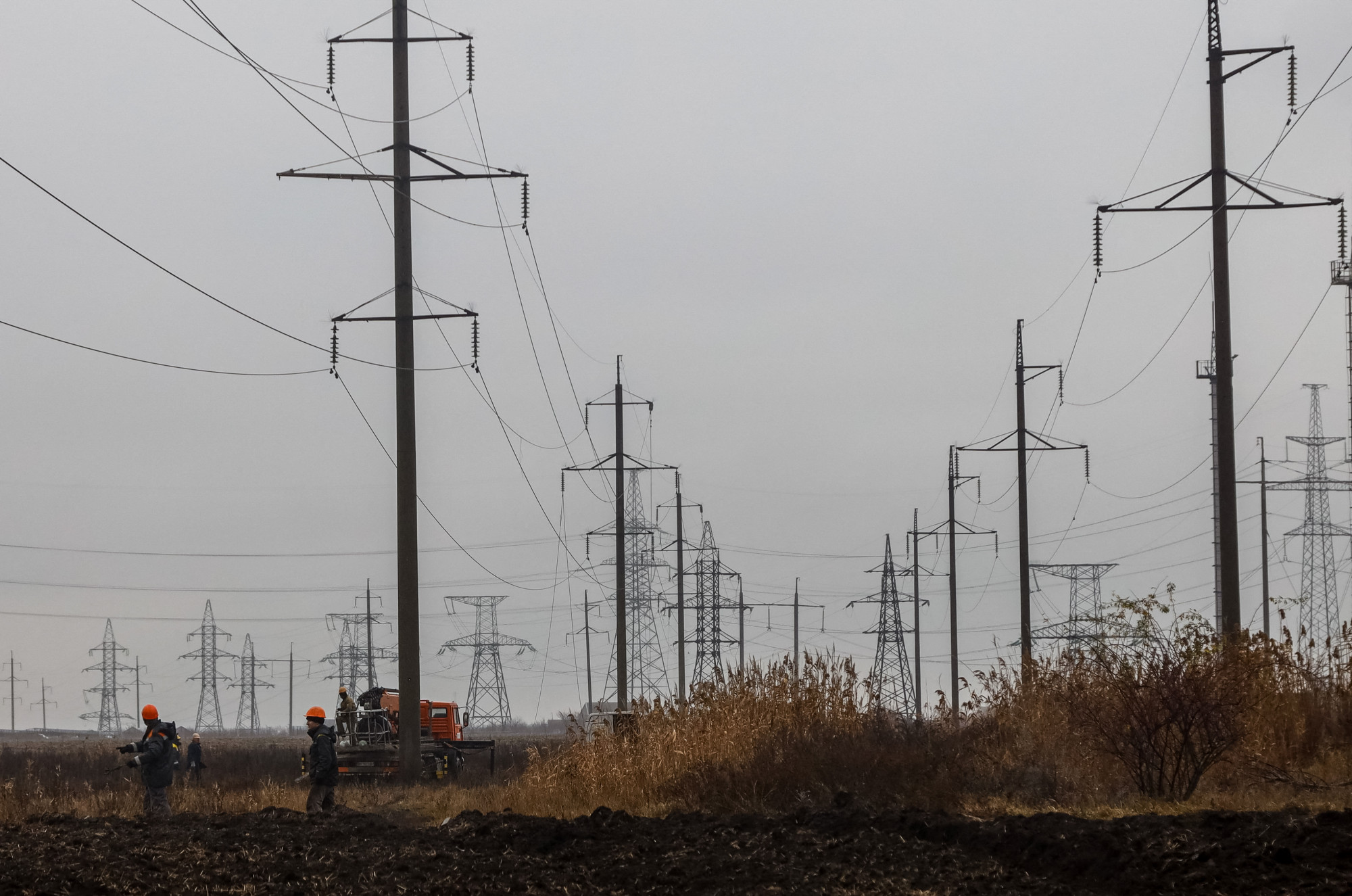 A megrongálódott vezetékek helyreállításán dolgozó szakemberek 2022. december 7-én, Odessza közelében.