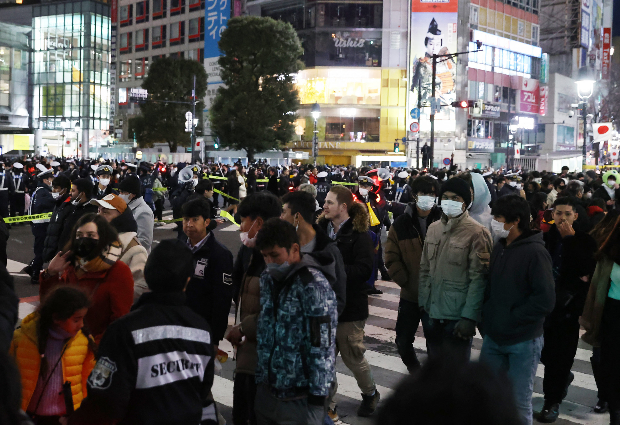 Járókelők Tokióban újévkor. Pedig a városban a covidjárványra tekintettel nem tartottak köztéri bulit.