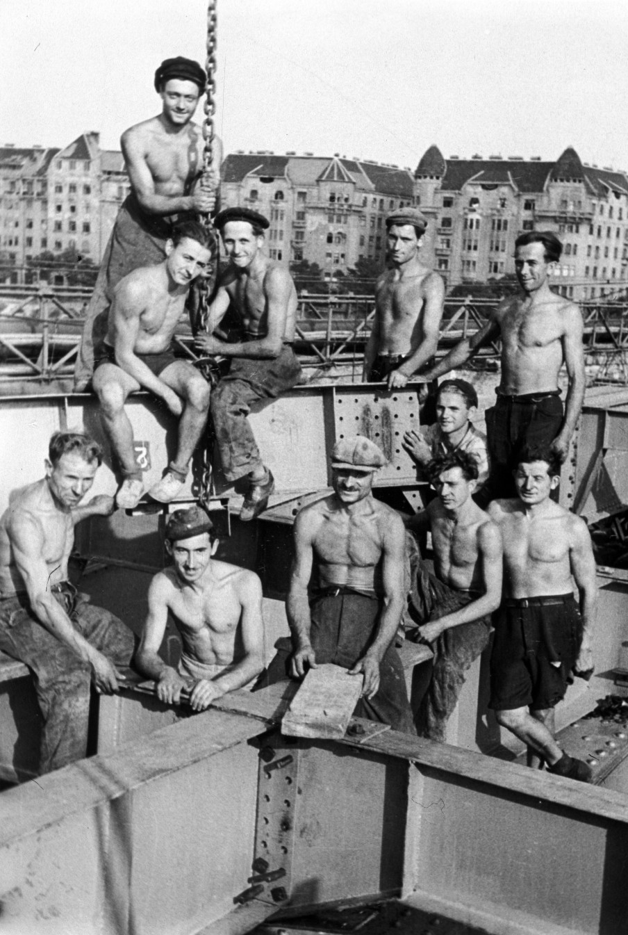 A Margit híd újjáépítésén dolgozó munkások 1947-ben, a háttérben a Palatinus házak láthatók.