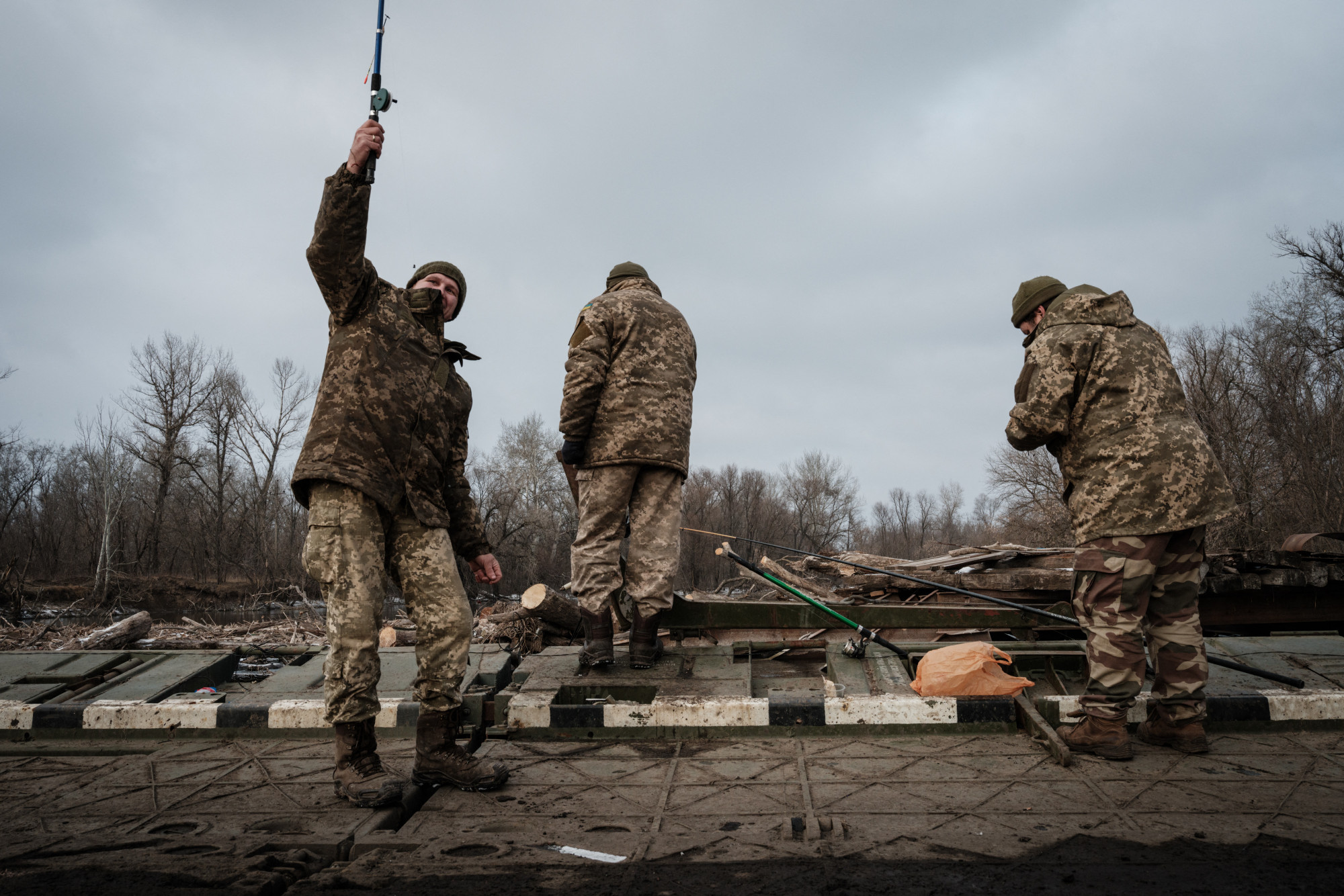 Ukrán katonák pecáznak a harcok szünetében egy donyecki pontonhídon.