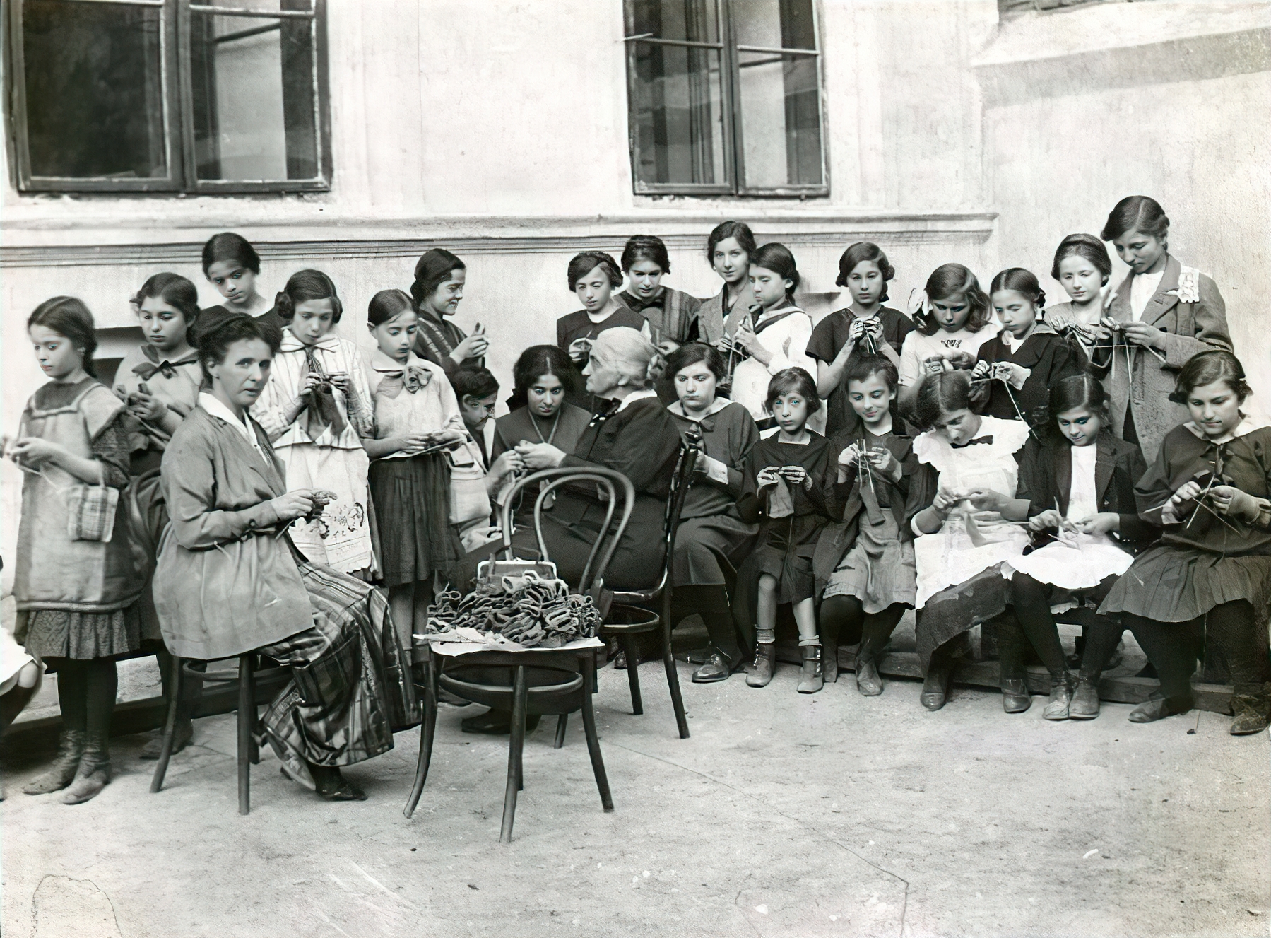 Hósapkát és érmelegítőt kötő gyerekek és asszonyok egy budapesti lányiskolában 1914-ben.
