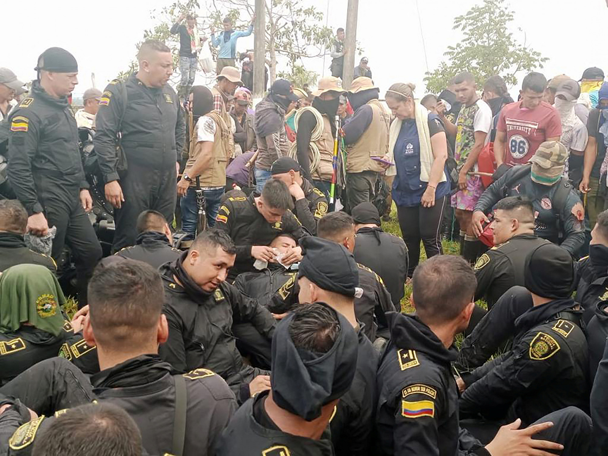 A túszul ejtett rendőrök a tüntetők gyűrűjében a kolumbiai San Vicente del Caguanban, ahol a demonstrálók azt követelték, hogy egy kínai olajcég az ígéreteit betartva fejlessze a környék infrastruktúráját.