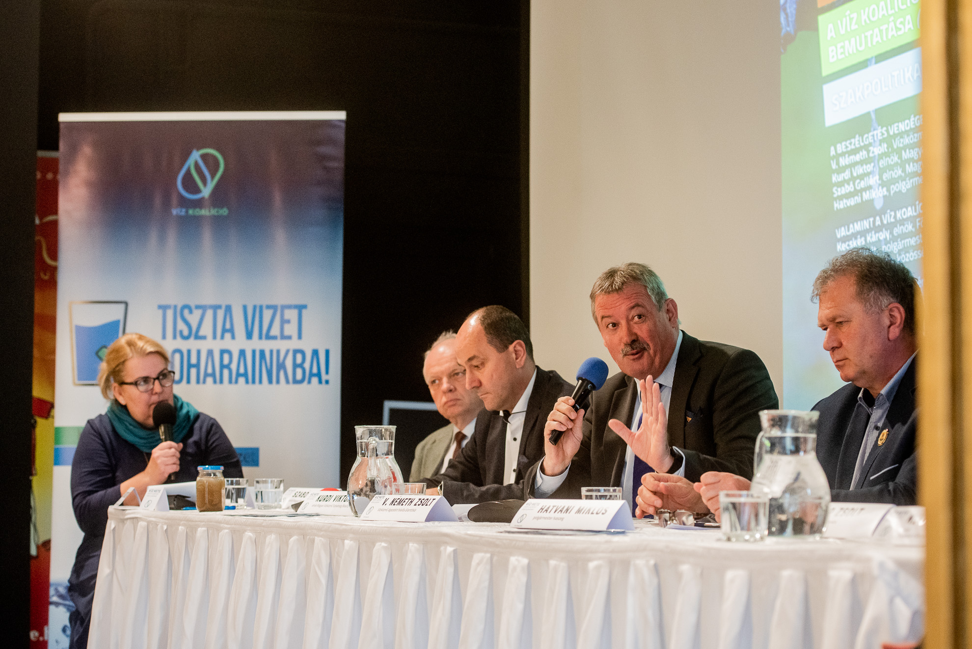 V. Németh Zsolt víziközmű-ágazatért felelős államtitkár mikrofonnal a Víz Koalíció szakmai kerekasztalbeszélgetésén 2023. március 27-én