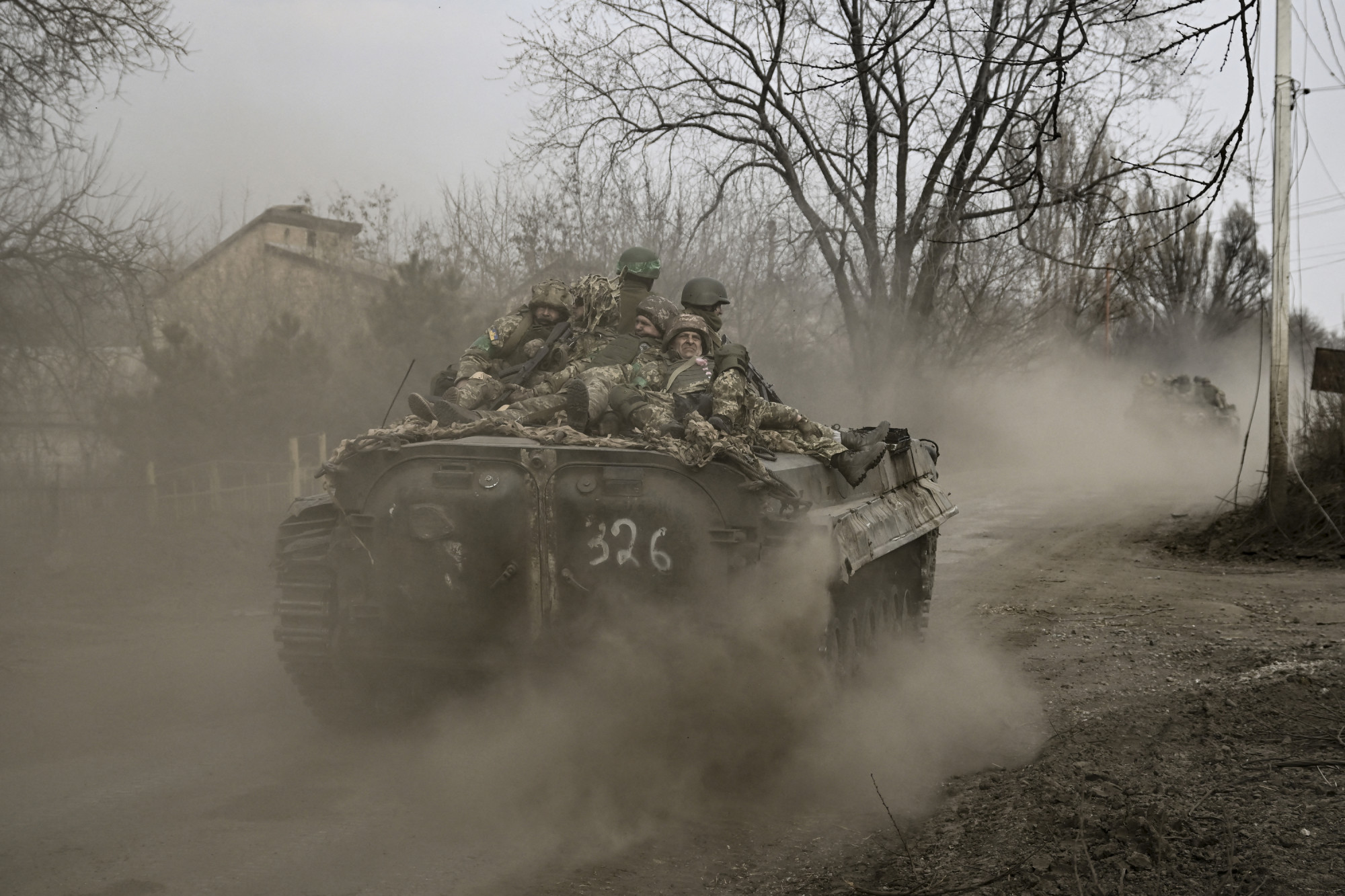 A bahmuti frontvonalba tartó ukrán gyalogosok egy BMP lövészpáncéloson a város határában 2023. március 22-én.