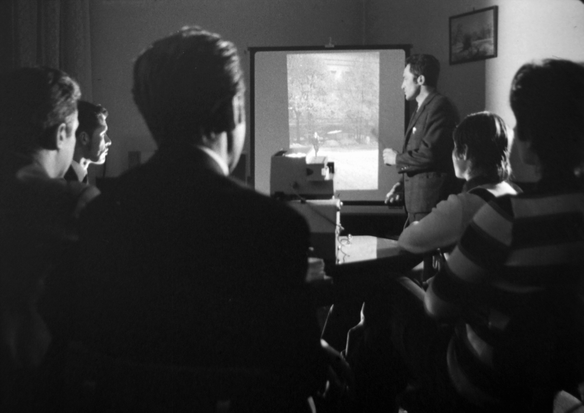 Az állambiztonság munkatársai operatív eszközzel készült titkos fotó kiértékelésén vesznek részt. Képkocka a Belügyminisztérium Filmstúdiójának oktatófilmjéből 1980-ból.