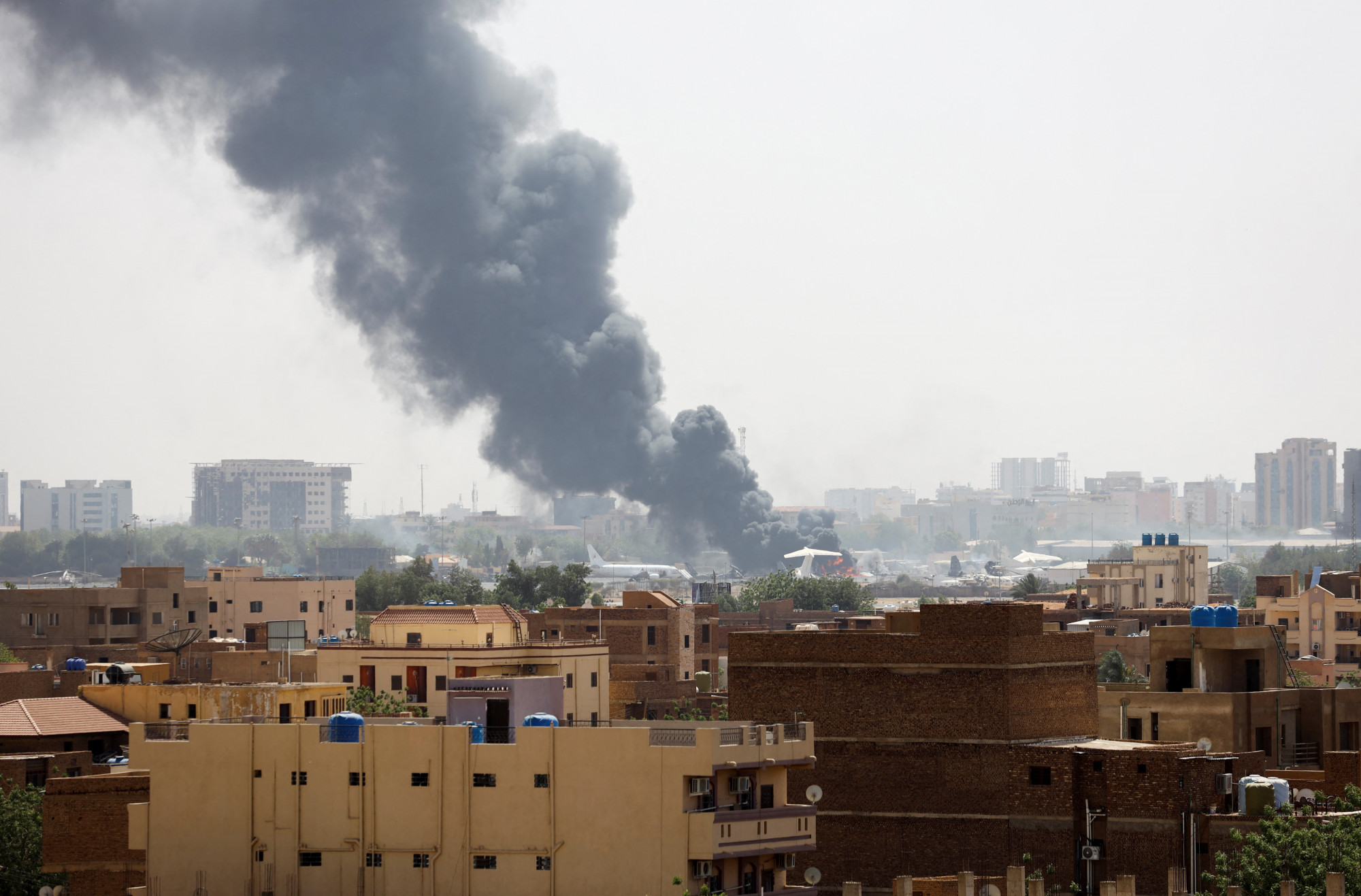Égő repülőgép füstje a kartúmi reptéren az RSF és a hadsereg összecsapásai alatt, 2023. április 17-én