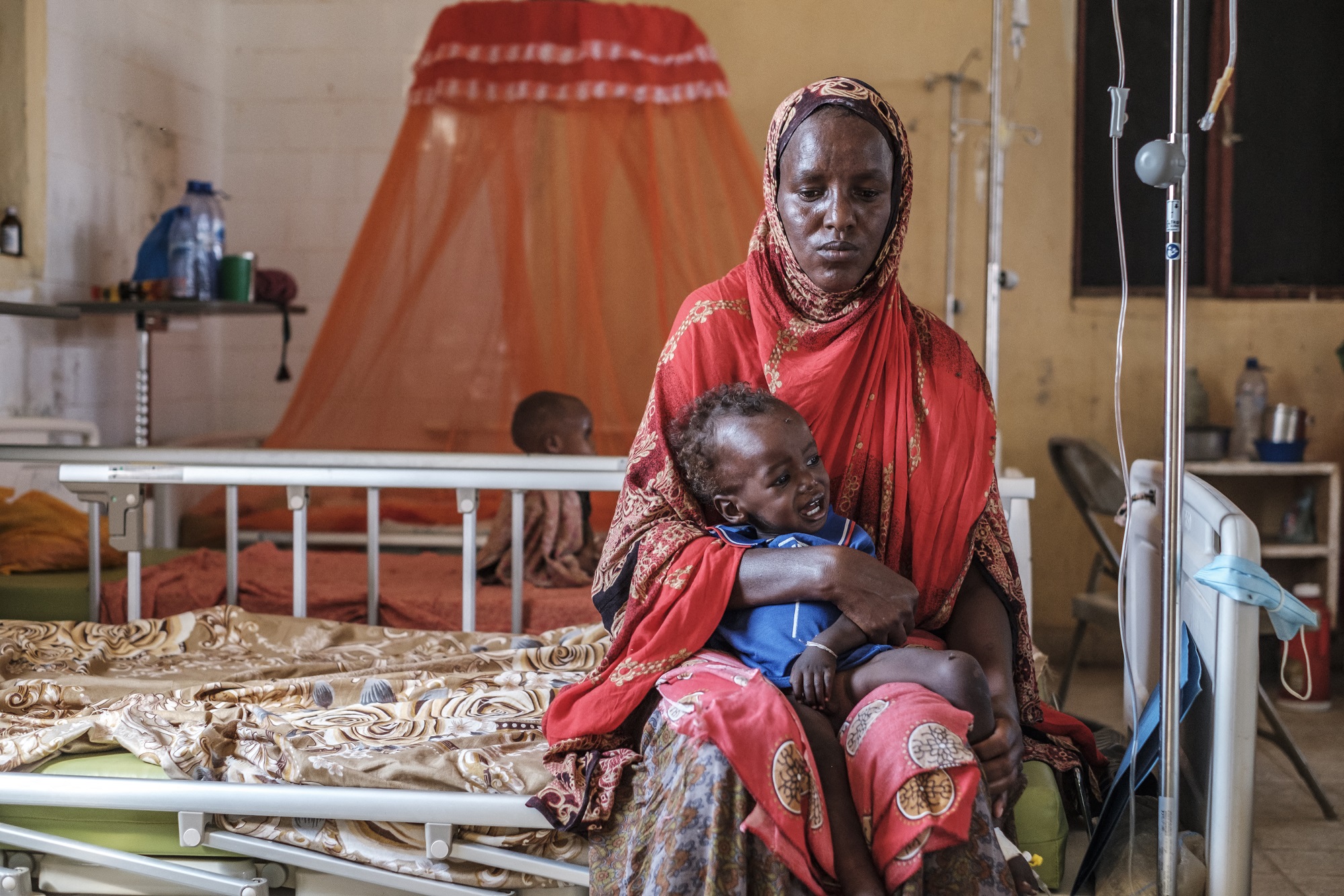 Egy nő a kezében tart egy gyereket a Gode Általános Kórház táplálkozási osztályán, az etiópiai Gode városában 2022. április 5-én.