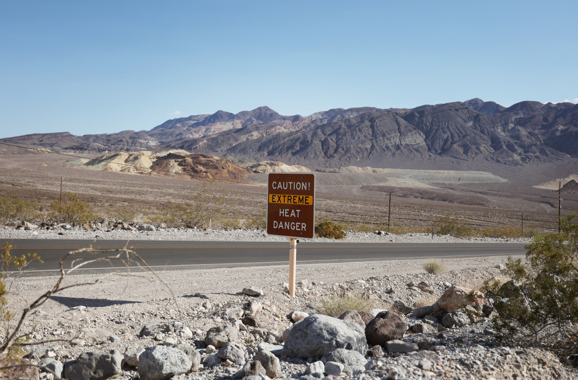 A szélsőséges hőségre figyemeztető tábla a 190-es főút mellett a Death Valley Nemzeti Parkban Kaliforniában, 2023. július 16-án.