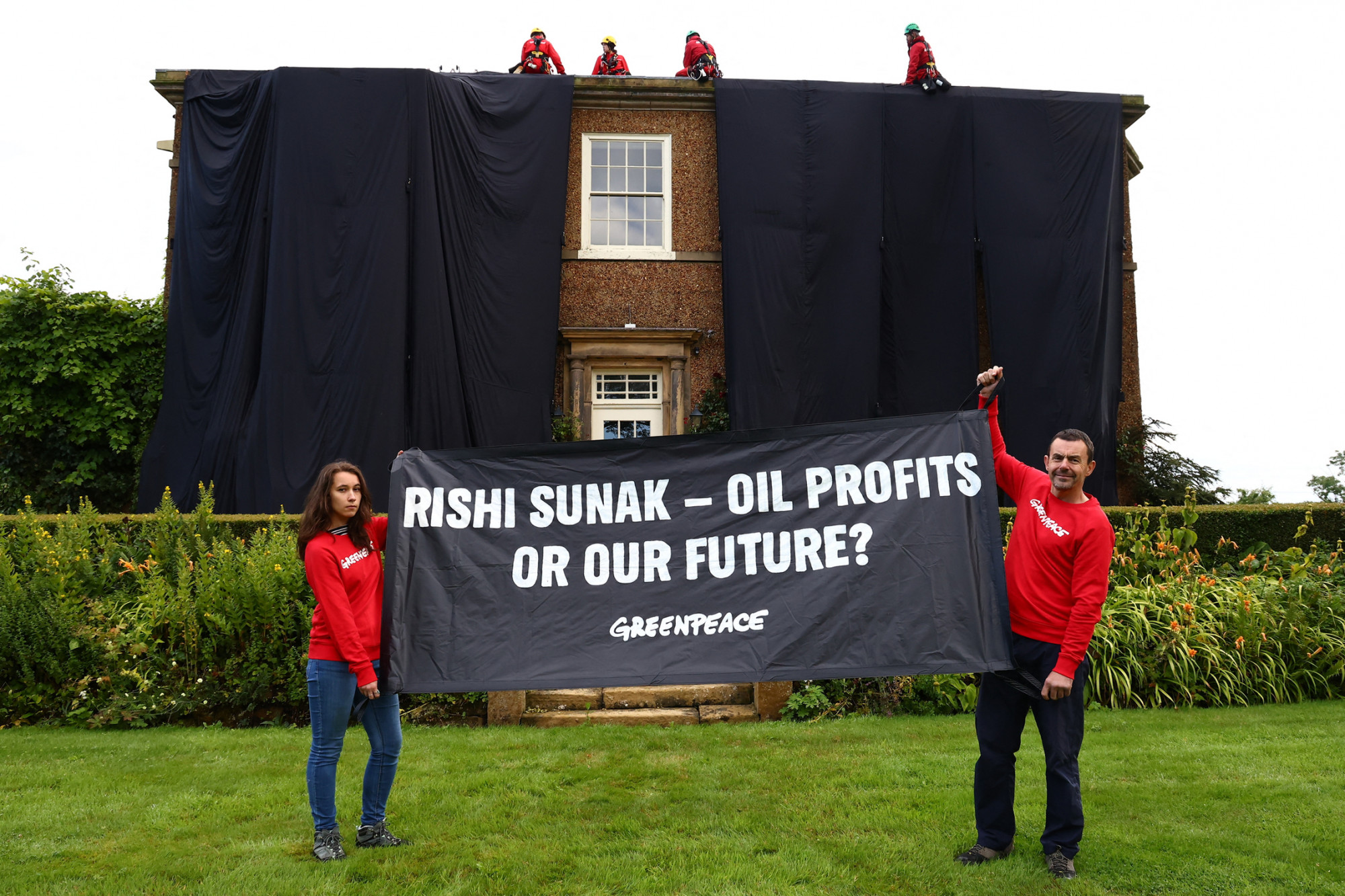 Felmásztak Rishi Sunak házának tetejére a Greenpeace aktivistái, hogy olajfekete drapériával takarhassák le