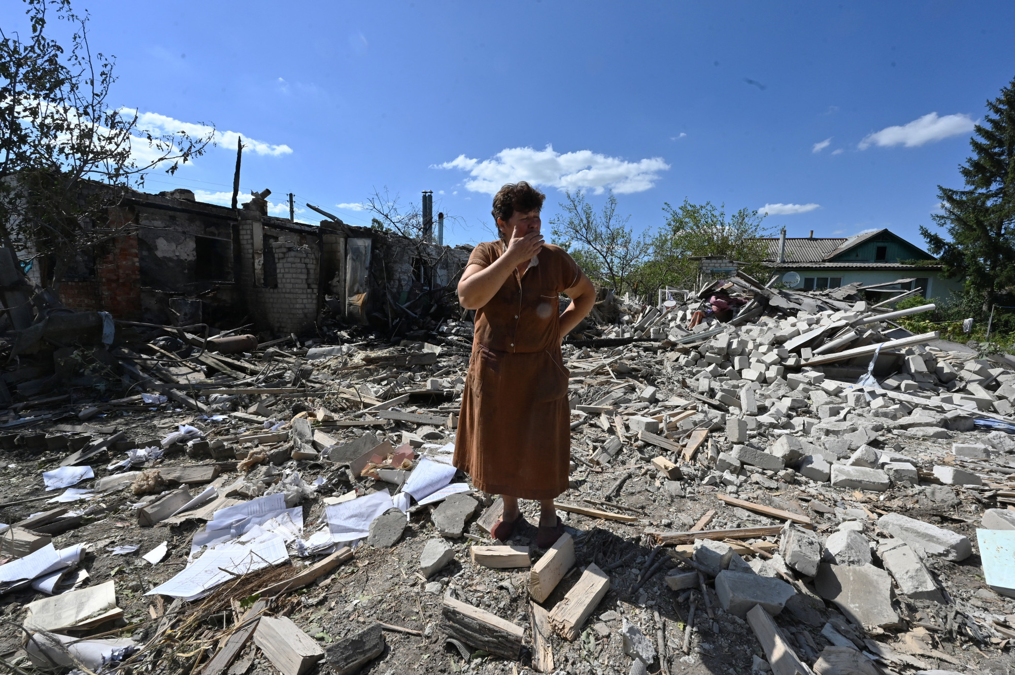 A 60 éves Tatjana Szkrjepnyikova, aki maga is könnyű repeszsérüléseket szenvedett, a szomszédja házának törmelékei között áll. A ház egy ágyúzást követően megsemmisült. Zaoszkij falu Kupjanszk mellett.