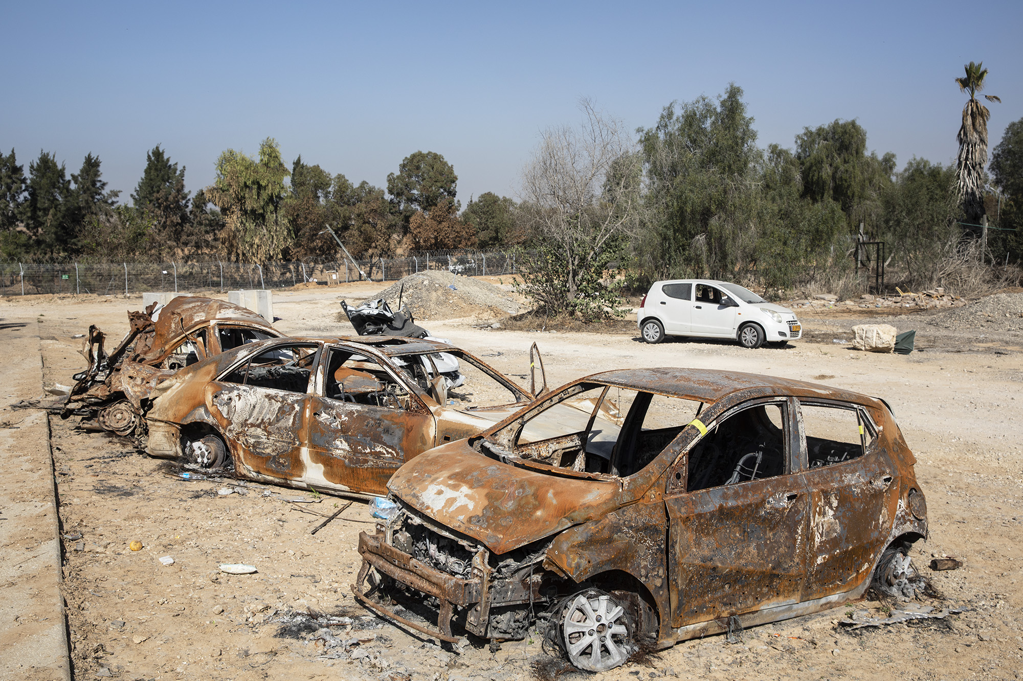 Kiégett autók, autóroncsok Kfar Aza kibucban a Hamász októberi terrortámadása után egy hónappal.