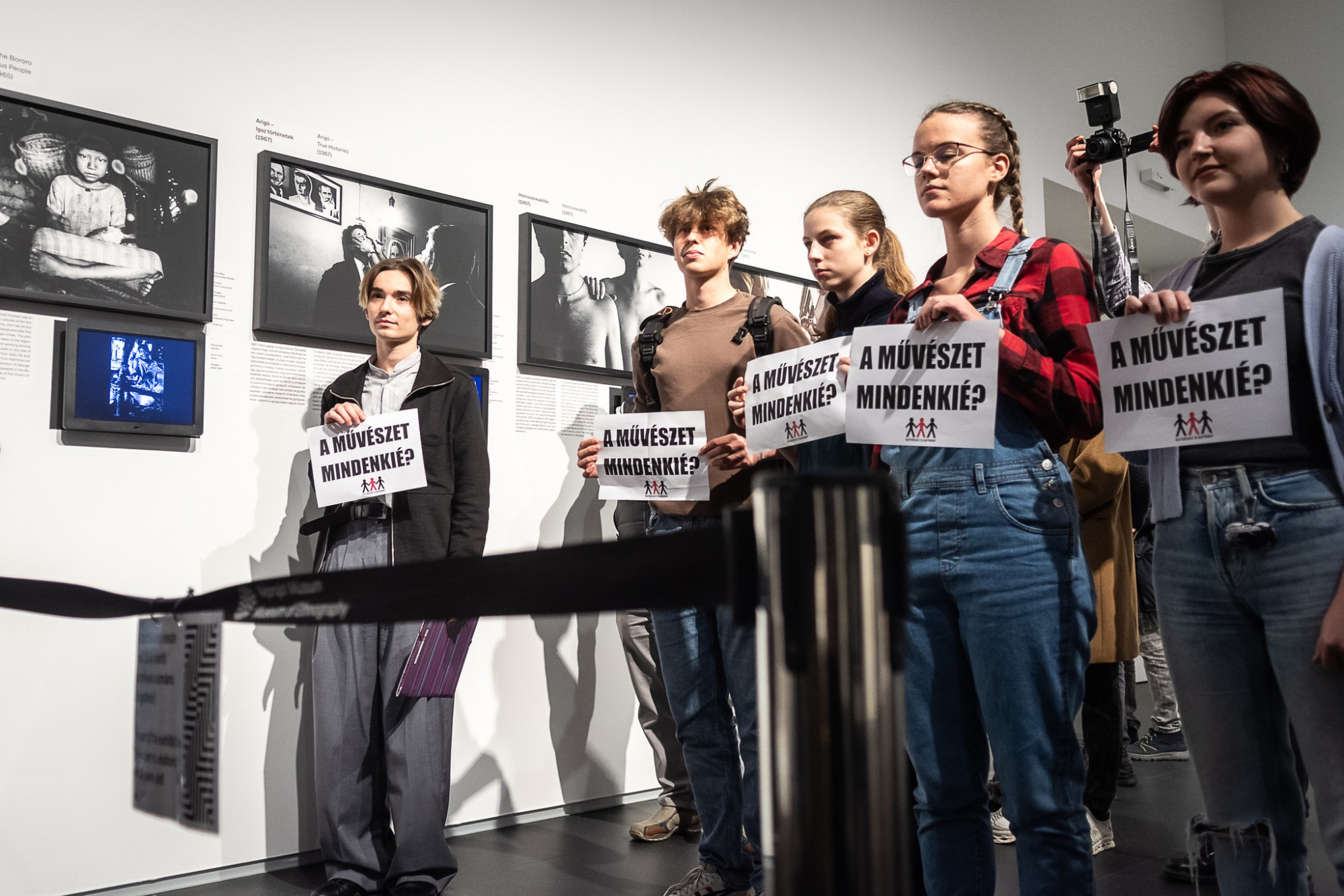 Az Egységes Diákfront által szervezett csütörtöki megmozdulás résztvevői a Néprajzi Múzeumban, Claudia Andujar elkordonozott képei előtt