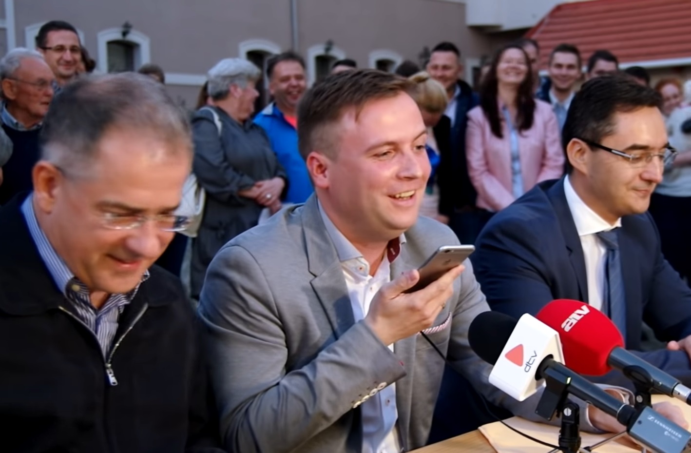 Türk László önkormányzati képviselő a 2017-es időközi választáson elért győzelme után Orbán Viktorral telefonál Kósa Lajos mellett.