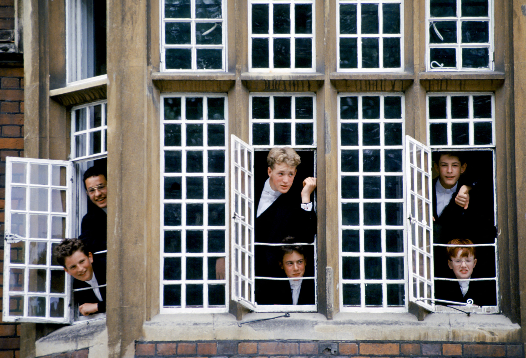 Formaruhába öltözött diákok az angliai Eton College ablakában