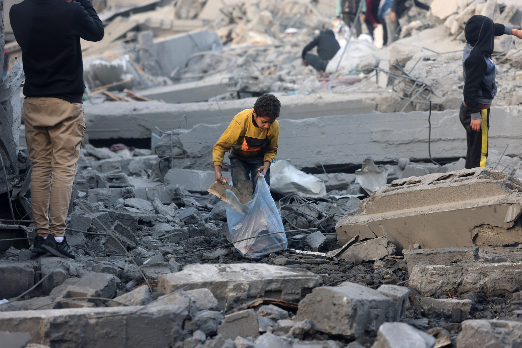 Palesztinok a gázai övezetben fekvő város, Rafa romjai között a január 25-én végrehajtott izraeli támadás után