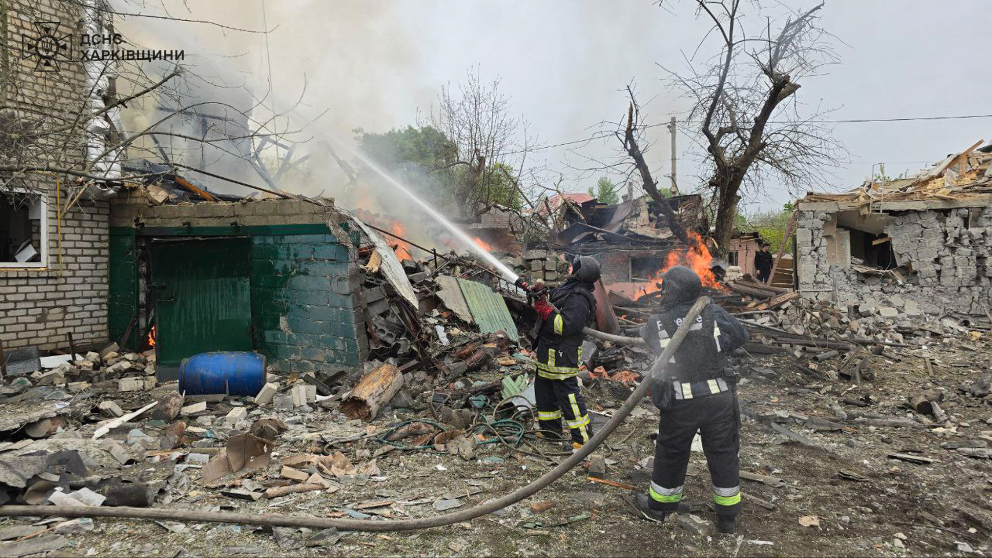 Tűzoltók küzdenek a lángokkal egy Harkiv közeli városban egy pénteki orosz rakétatámadás után.