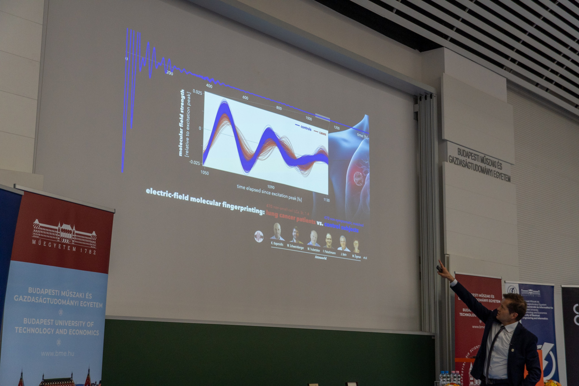 Krausz Ferenc Nobel-díjas fizikus éppen azt az ábrát mutatja előadásában, ahol a normál referenciához képest (kékkel) eltér a tüdőrákos betegek (pirossal) vérének molekuláris ujjlenyomata
