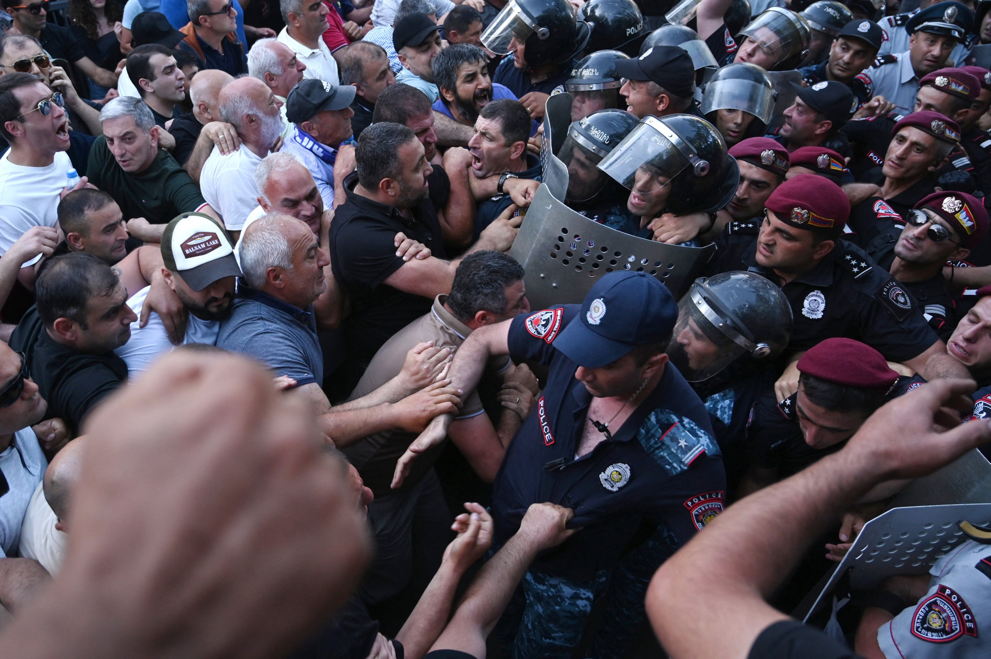 Kormányellenes tüntetők és rendőrök Jerevánban június 12-én a Parlament előtt.