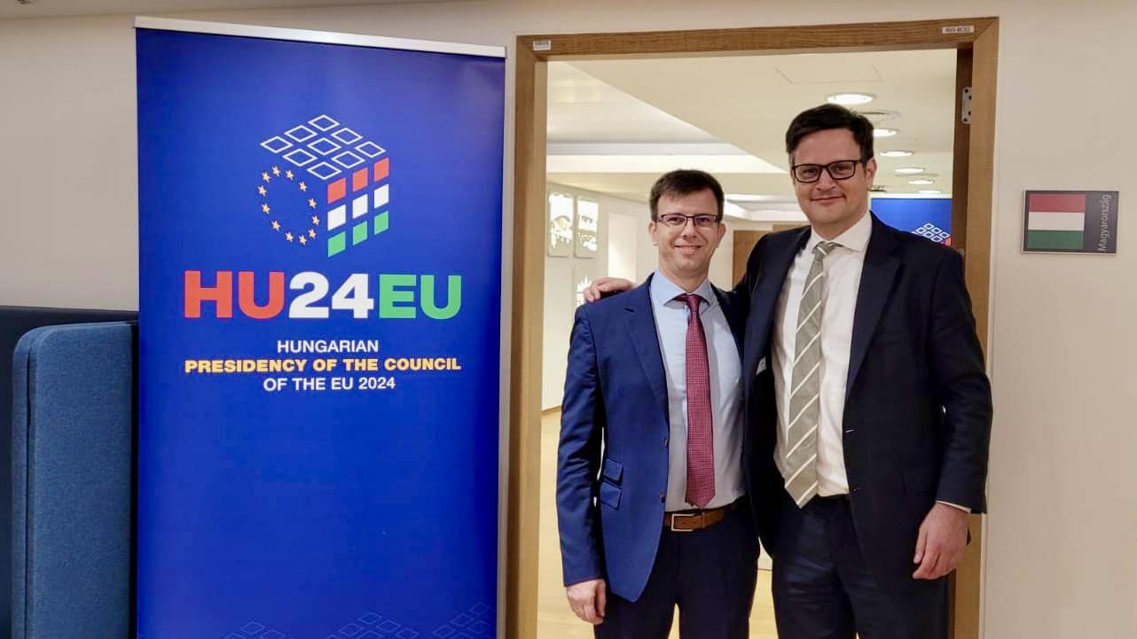 Bóka János uniós ügyekért felelős miniszter és Ódor Bálint brüsszeli állandó képviselő a magyar elnökség logóját és jelmondatát ábrázoló rollup mellett
