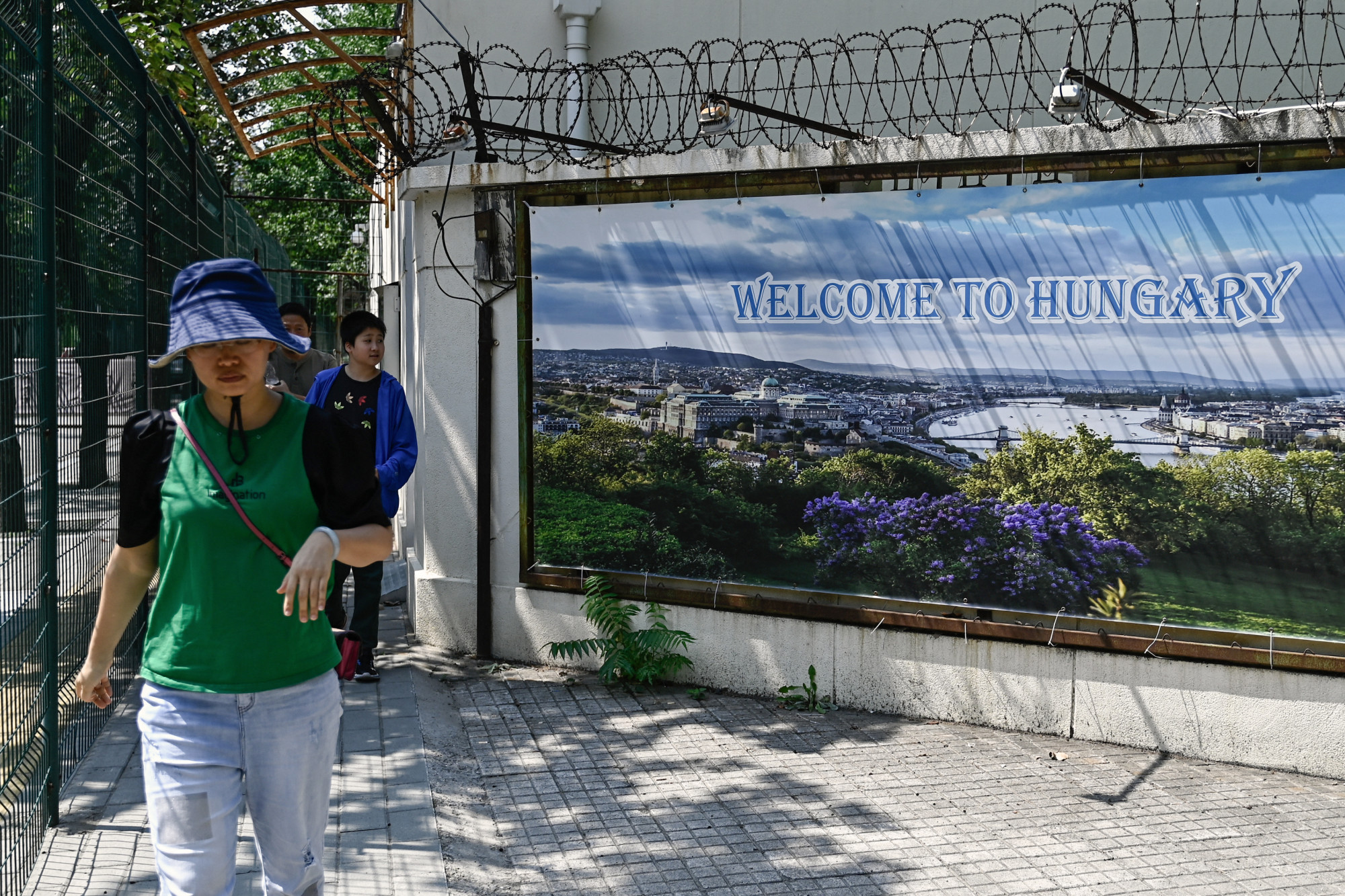 Emberek a pekingi magyar nagykövetség előtt sétálnak el a Welcome to Hungary feliratú táblák mellett 2024. július 8-án.