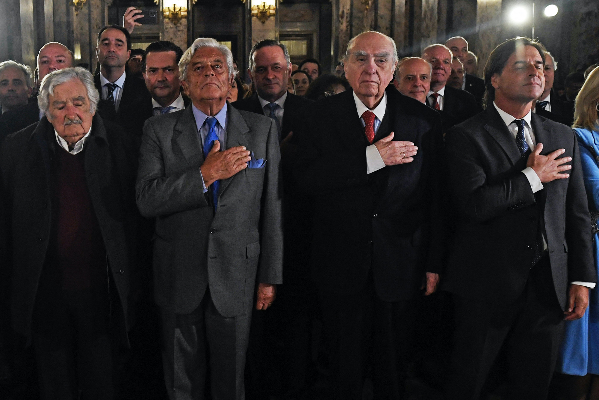 Uruguay volt elnökei, Jose Mujica, Luis Alberto Lacalle, Julio Maria Sanguinetti és a jelenlegi elnök, Luis Lacalle Pou az ország himnuszát hallgatják egy megemlékezésen, Montevideóban, 2023-ban