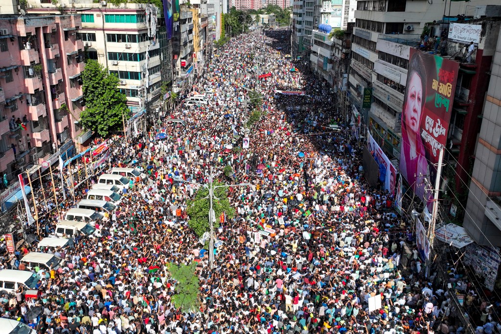 A légi felvételen a Bangladesi Nacionalista Párt (BNP) aktivistái gyülekeznek Khaleda Zia BNP-elnök plakátja mellett egy dhakai gyűlésen 2024. augusztus 7-én.