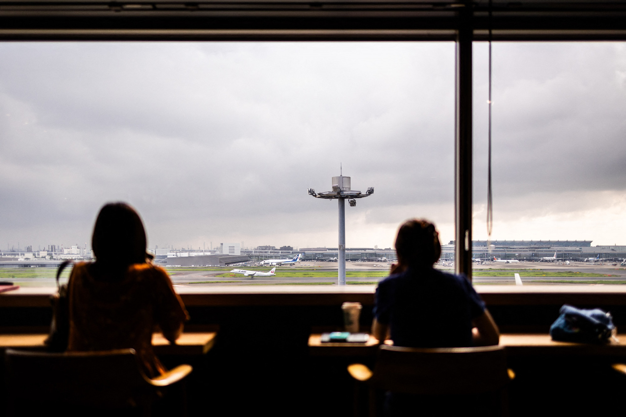 Várakozók a Haneda repülőtéren, Tokióban.