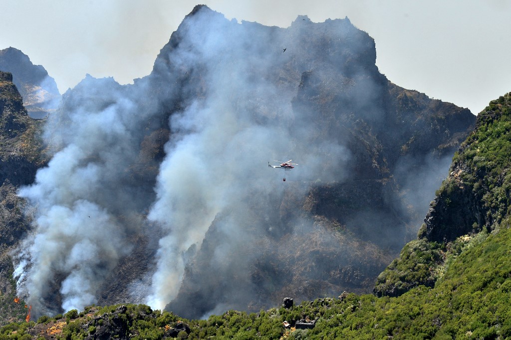 Helikopter köröz a Pico do Areeiro-hegység növényzetét pusztító lángok fölött 2024. augusztus 21-én