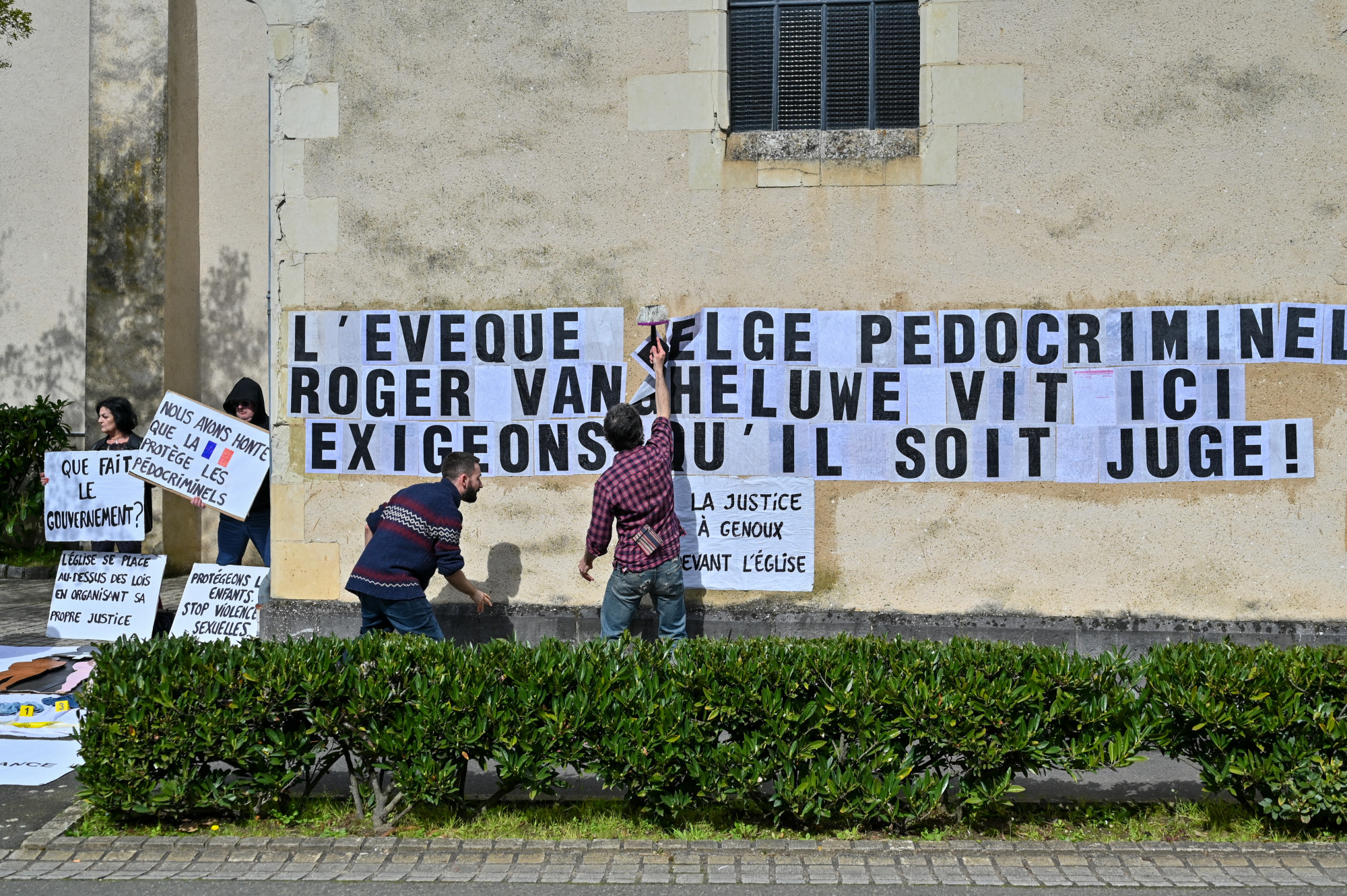 A Mouv enfants egyesület 2024 márciusi akciója a Saint-Pierre de Solesmes apátság előtt. Az aktivisták Roger Vangheluwe bűneit írták a homlokzatra, és egy bűnügyi helyszínt állítottak elő gyermekruhákkal és játékokkal.