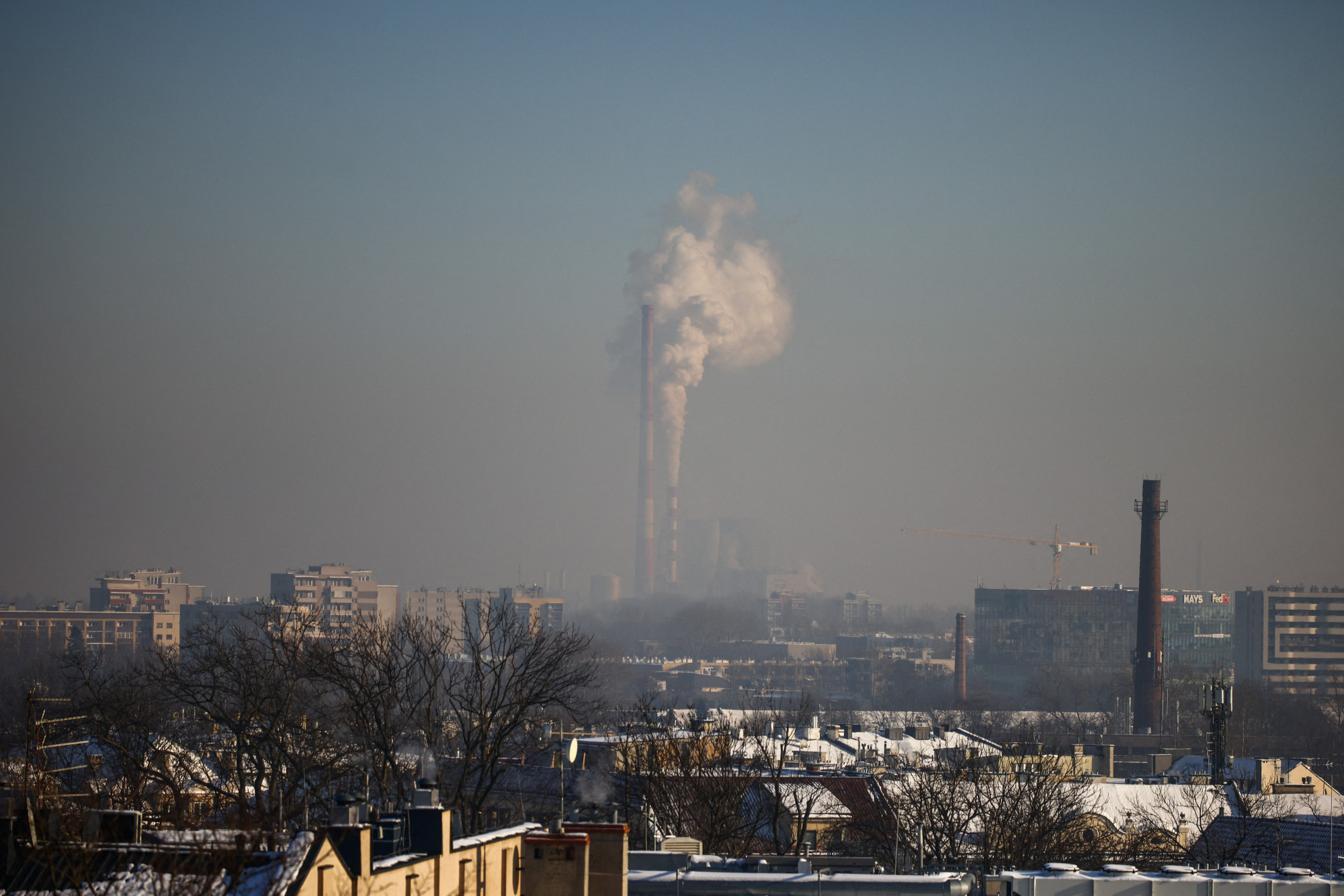 Krakkó háttérben a Krakow-Leg erőmű kéményeiből kiömlő füsttel. Mivel 2024 január 10-én Krakkóban a PM10 részecskék koncentrációja meghaladta az elfogadható napi értéket, 24 órára ingyenessé tették a város tömegközlekedését.