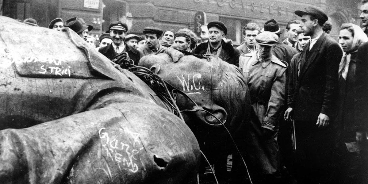 Sztálin ledöntött szobra W.C., gané és strici feliratokkal