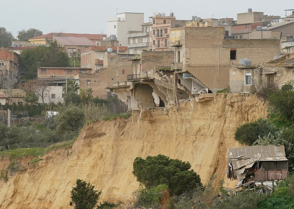 Tűzoltók mentik a könyveket a szicíliai Niscemi város szakadék szélére került könyvtárából