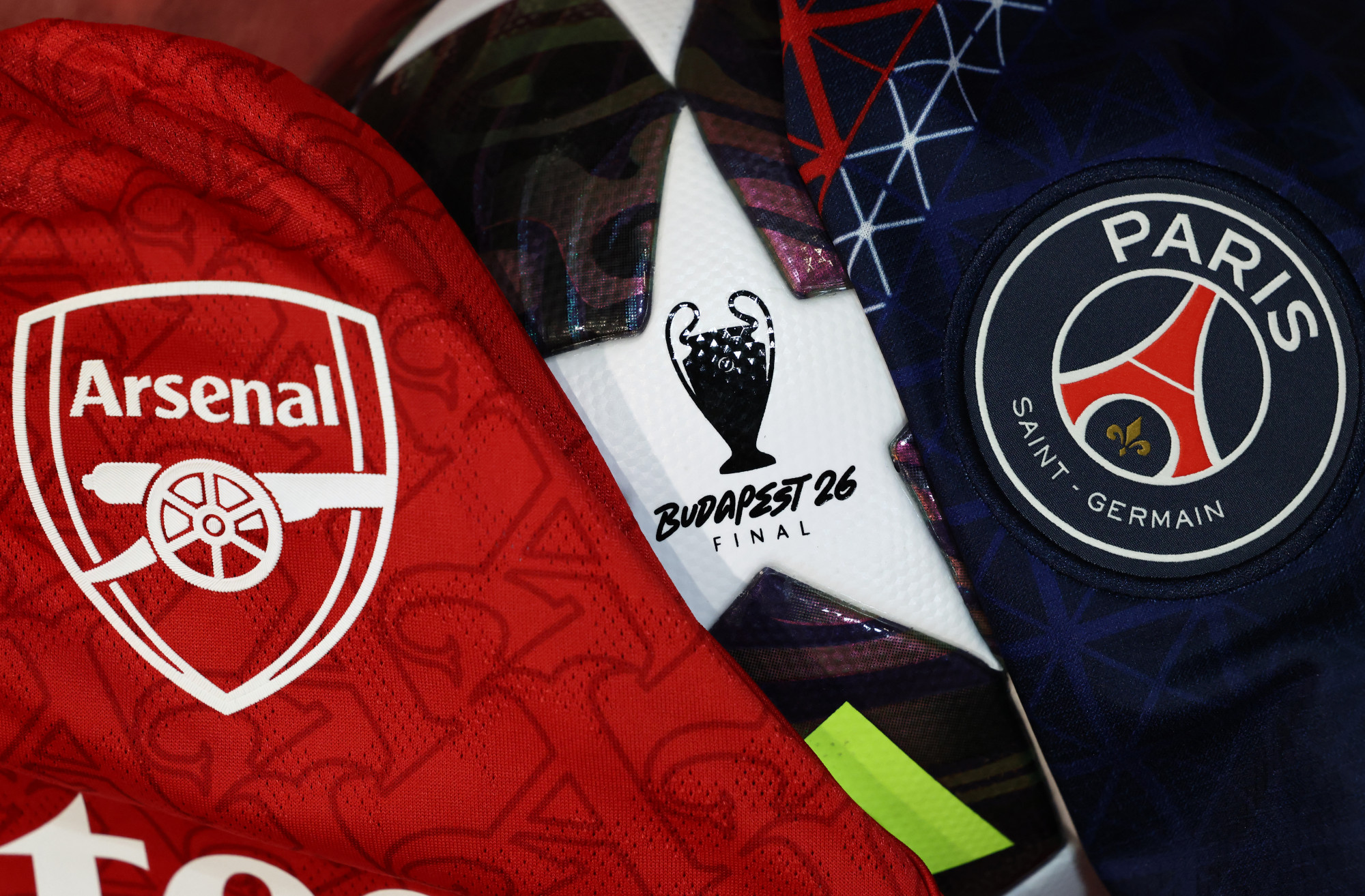 (FILES) This photograph shows the badges on Paris Saint Germain (R) and Arsenal (L) football shirts in Paris on May 19, 2026. Paris Saint-Germain will play Arsenal in the UEFA Champions League final football match in Budapest on May 30, 2026. (Photo by FRANCK FIFE / AFP)
