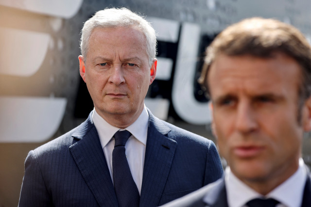 France's Minister for Economy and Finances Bruno Le Maire (L) listens as France's President Emmanuel Macron (R) addresses the media during a visit to the powders and explosives company Eurenco plant in Bergerac, southwestern France, on April 11, 2024. (Photo by Ludovic MARIN / POOL / AFP)